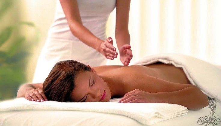 operatrice che esegue un massaggio schiena su cliente su lettino benessere