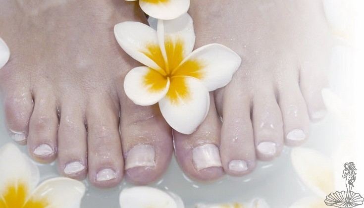 immagine piedi uniti ben curati abbelliti da un fiore al centro.